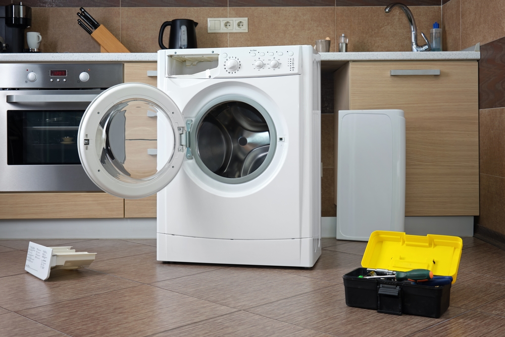 A,disassembled,household,washing,machine,against,the,background,of,a