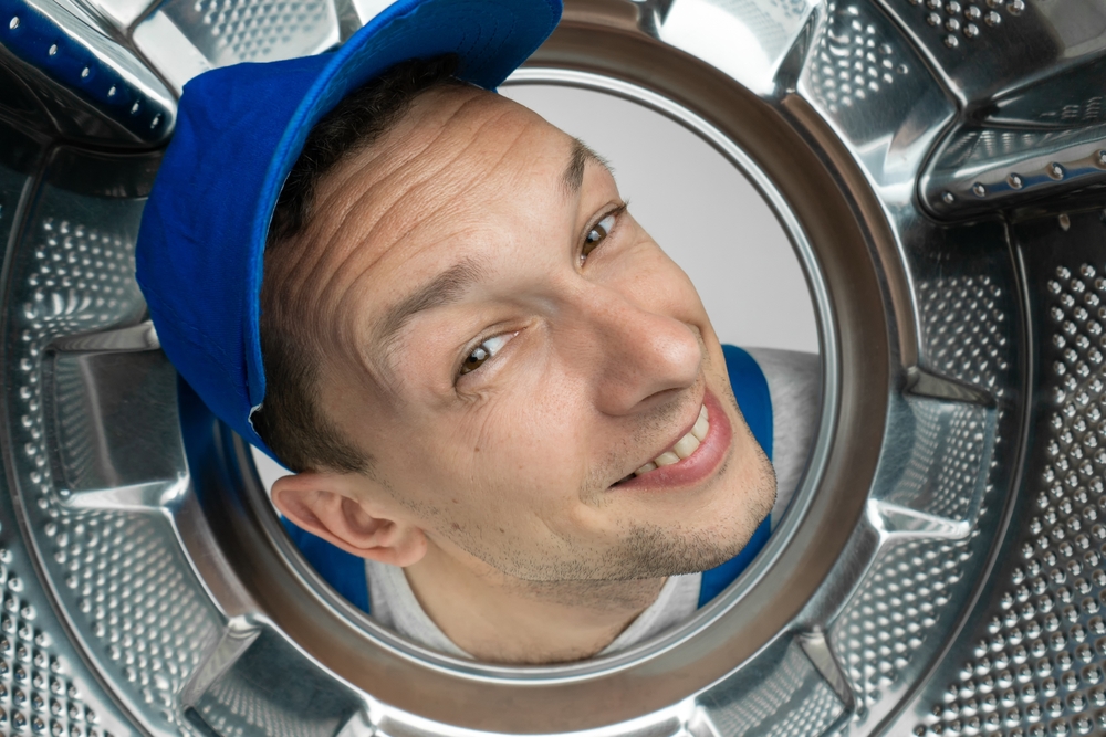 Smiling,curious,male,repairman,in,uniform,got,his,head,into