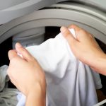 Woman,hand,taking,wet,white,clothes,out,of,automatic,washing